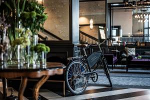 ein Fahrrad, das neben einem Tisch in einem Restaurant geparkt ist in der Unterkunft Hotel Victoria in Stavanger