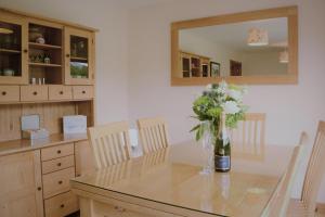 un comedor con una mesa con un jarrón de flores en Torcastle House, en Fort William