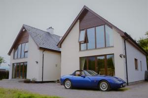 a blue car parked in front of a house at Torcastle House in Fort William