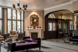 ein Wohnzimmer mit Kamin und lila Möbeln in der Unterkunft Hotel Victoria in Stavanger