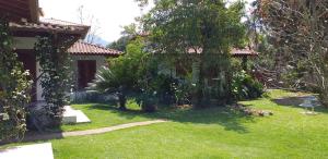 a yard with a house with a green lawn at Bangalôs Parque Verde in Paraty