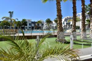 a resort with palm trees and a swimming pool at Casa La Zenia in Playas de Orihuela