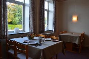 a dining room with two tables and a window at Motel Sydvest in Skærbæk