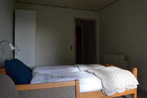 an unmade bed in a room with at Motel Sydvest in Skærbæk