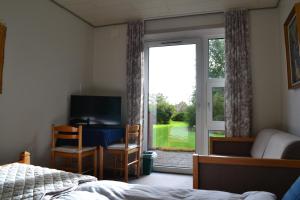 a bedroom with a bed and a sliding glass door at Motel Sydvest in Skærbæk