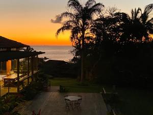 una casa con vistas a la puesta de sol del océano en Villa Galiileu Ilhabela, en Ilhabela