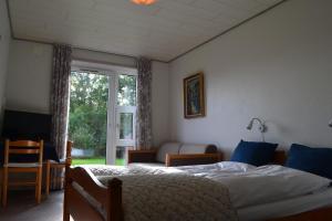 a bedroom with a bed and a desk at Motel Sydvest in Skærbæk