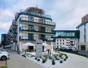 a large building with a parking lot in front of it at Your Holidays Bel Mare II in Międzyzdroje