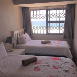 a bedroom with two beds and a window with the ocean at Villa Siesta Flat No 1 in Margate