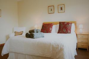 a bedroom with a white bed with two teddy bears on it at Maybank in Fort William