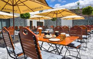 a wooden table with chairs and umbrellas on a patio at Resort Hotel in Bodenmais