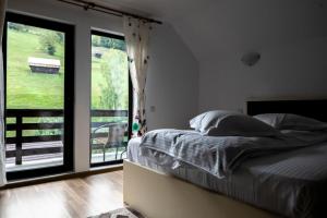 a bedroom with a bed and a large window at Casa Dora in Moieciu de Sus