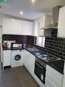 a kitchen with a washing machine and a washer at Deluxe En-Suite Bedroom In the Centre of Watford in Watford