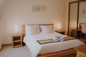 a bedroom with a large white bed with towels on it at Shepherds Rest in Fort William