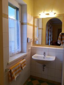 un bagno con lavandino e specchio di Gasthof Zur Post a Bad Goisern Altre 14 foto