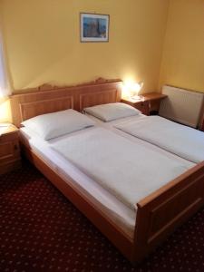 a bedroom with two beds with white sheets and two lamps at Gasthof Zur Post in Bad Goisern