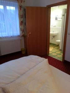 una camera con letto e un bagno con lavandino di Gasthof Zur Post a Bad Goisern