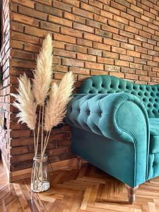 ein blaues Sofa in einem Zimmer mit Ziegelwand in der Unterkunft Loft Apartman Menhetn in Šabac