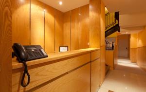 馬德里的住宿－太陽門米拉多酒店，电话坐在一个房间里的一个柜台上