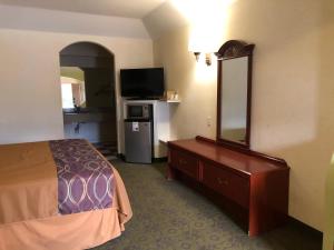 Habitación de hotel con cama y espejo grande en Porter Executive Inn & Suites, en Porter