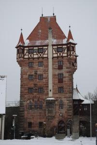 a tall brick building with a roof in the snow at Hotel Burg Abenberg in Abenberg