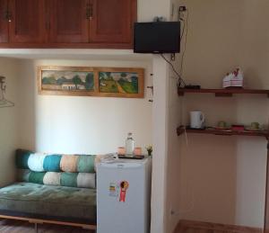カシャンブにあるSuíte elegante Caxambuのリビングルーム(冷蔵庫、ソファ付)