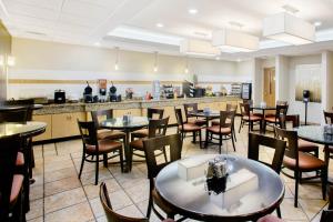 a restaurant with tables and chairs and a bar at La Quinta by Wyndham Springfield South in Springfield