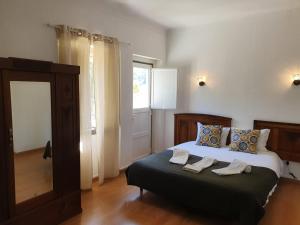 ein Schlafzimmer mit einem Bett mit zwei Handtüchern darauf in der Unterkunft Lanui Vintage Guest House in Sintra