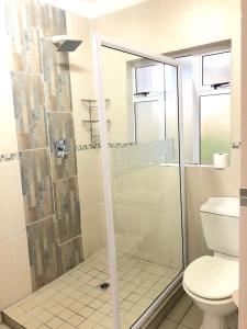 a bathroom with a shower and a toilet at Caribbean Estates Villa B10 on Barbados in Port Edward