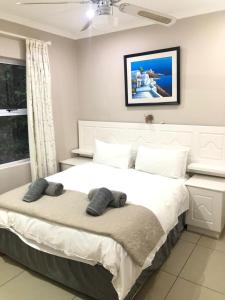 a bedroom with a large white bed with two pillows on it at Caribbean Estates Villa B10 on Barbados in Port Edward