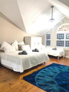 a bedroom with two beds and a blue rug at Caribbean Estates Villa B10 on Barbados in Port Edward