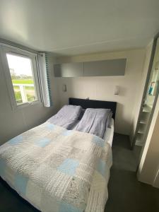 a small bedroom with a bed with a window at Charme Logies Wadzout't in Westerland