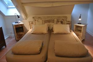 a bedroom with a large bed with two pillows at Le Moulin de Planiol in Le Vigan