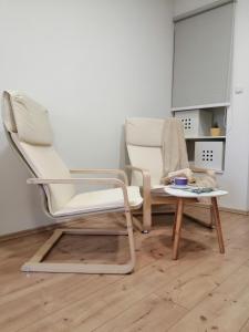 2 weiße Stühle und ein Tisch in einem Zimmer in der Unterkunft Studio Apartman ''Nicole'' in Pula