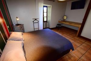 1 dormitorio con 1 cama grande y suelo de madera en Le Moulin de Planiol en Le Vigan