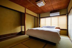 sypialnia z łóżkiem i oknem w obiekcie Kyoto Cosy House 1946 by YADORU KYOTO HANARE w mieście Kioto