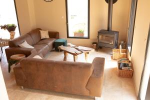 Una sala de estar con dos sofás y una estufa de leña. en Domaine des Jammetous - Hotel and Yoga Retreat Center, en La Magdelaine-sur-Tarn