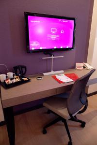 a desk with a television and a computer on it at Crowne Plaza Verona Fiera, an IHG Hotel in Verona