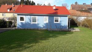 ein blaues Haus mit rotem Dach auf einem Hof in der Unterkunft Ferienhaus Jütte in Ebergötzen