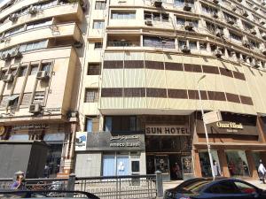 a tall building with a sun hotel on a city street at Sun Hostel Cairo in Cairo