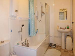 a bathroom with a bath tub and a sink at Becket apartment in Yeovil