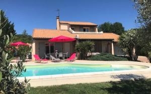 a house with a swimming pool in front of a house at La Villa des 3 ifs in Vallon-Pont-dʼArc