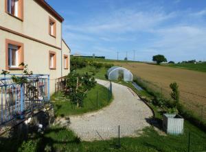 una casa con jardín junto a un campo en Gites des Camparros, en Nailloux