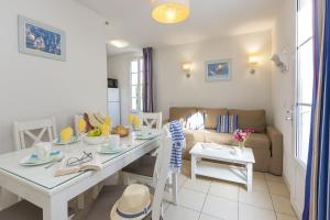 a living room with a table and a couch at Résidence Odalys Terre Marine in Saint-Pierre-dʼOléron