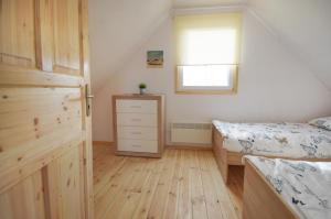 Un dormitorio con una cama y una cómoda y una ventana. en "Domki na Miłej "Niechorze, en Niechorze