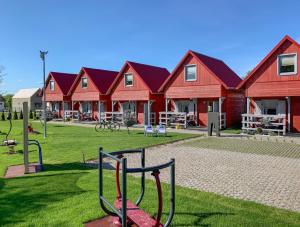 a group of red houses with a playground at Domki na Miłej in Niechorze