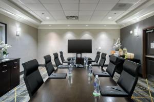 uma sala de conferências com uma mesa longa e cadeiras pretas em Holiday Inn & Suites Atlanta Airport North, an IHG Hotel em Atlanta