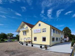een groot geel gebouw met een parkeerplaats bij Hotel Andrea in Crailsheim