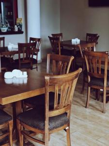 a dining room with wooden tables and chairs at Amore Hotel in Gudauta