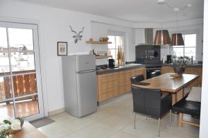 a kitchen with a refrigerator and a table in it at Avenida Mountain Resort A11 in Kaprun